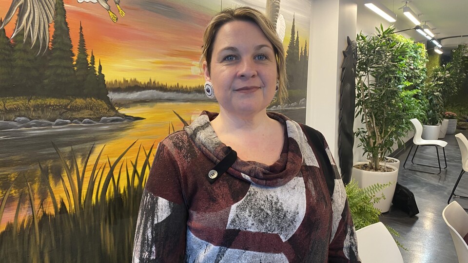 Roberta Billingsley devant une murale représentant un aigle.