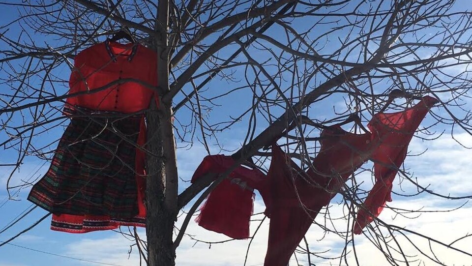 Des robes rouges sont accrochées à un arbre à la mémoire des femmes et des filles autochtones disparues et assassinées.