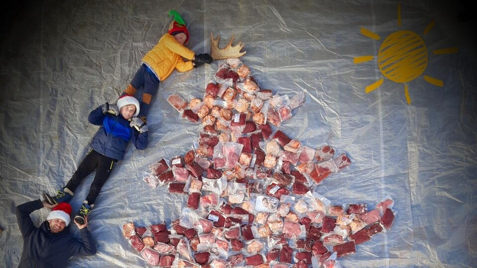 Jonathan Bélanger prend la pose avec ses deux jeunes garçons et les paquets de viande, placés en forme de sapin de Noël.