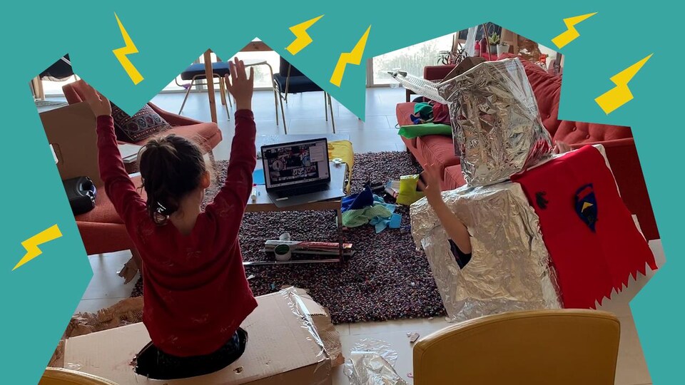 Deux enfants déguisés en robots dansent devant un ordinateur
