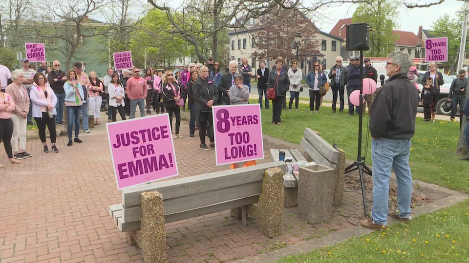 Des dizaines de personnes brandissent des pancartes sur lesquelles il est écrit « Justice pour Emma » et « Huit ans, c'est trop long ».