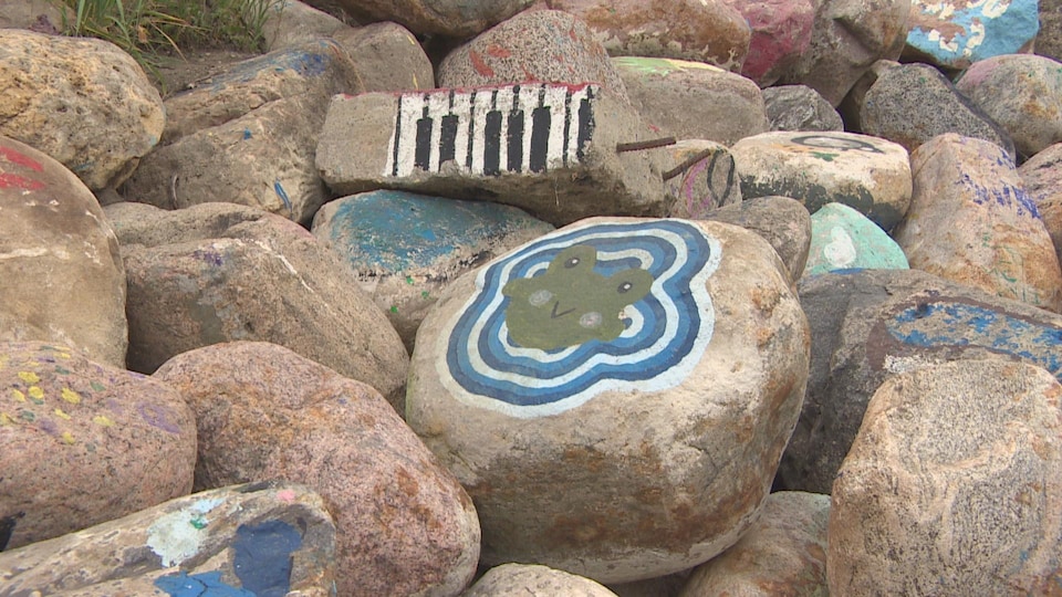 Illustration d'une grenouille et d'une série de touches de pianos sur des roches près de la rivière Saskatchewan Sud, à Saskatoon. 
