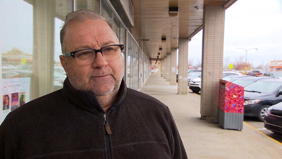 Rodrigue Vigneault est dans la rue. Il regarde la caméra.