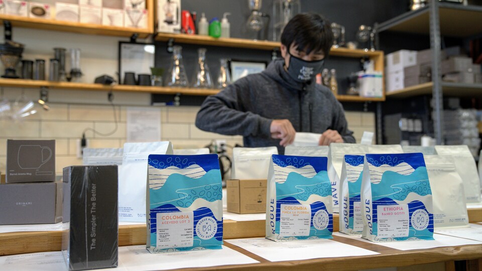 Un homme prépare des commandes dans un café.