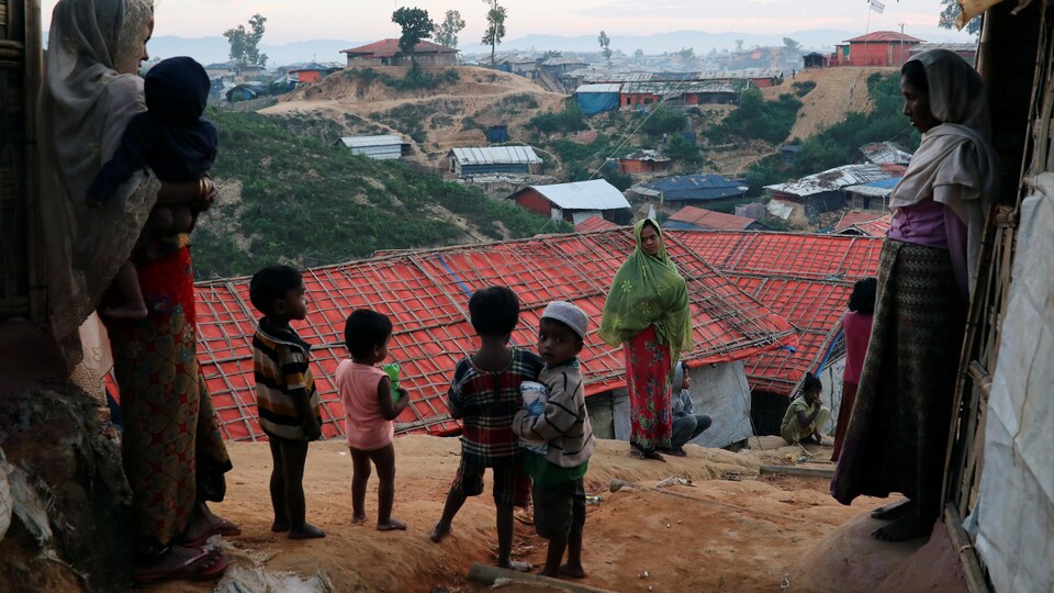 Des enfants rohingyas se tiennent sur une butte qui surplombe un camp de réfugiés.