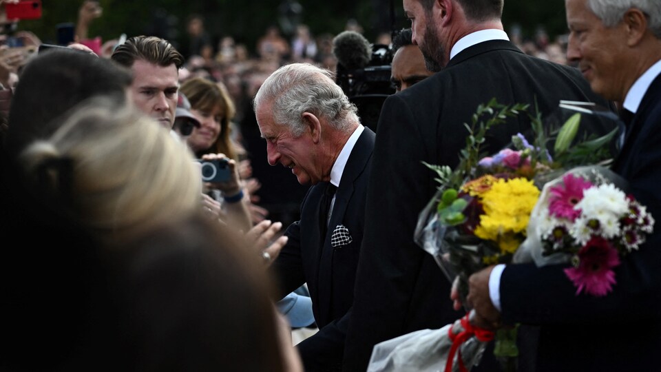 Le roi Charles III de Grande-Bretagne salue la foule à son arrivée au palais de Buckingham à Londres, le 9 septembre 2022.