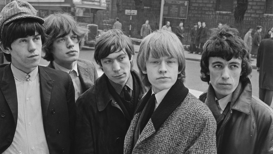 Les cinq hommes prennent la pose alors qu'ils sont photographiés sur le trottoir d'une rue à Londres.