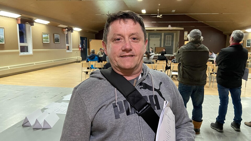 Francis Bisson pose pour la caméra en souriant légèrement.
