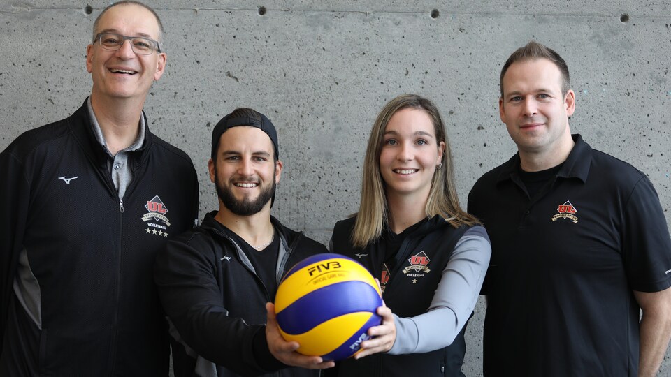 Pascal Clément, Rémi Cadoret, Maud Chapleau et Danny Da Costa posent avec un ballon de volleyball.