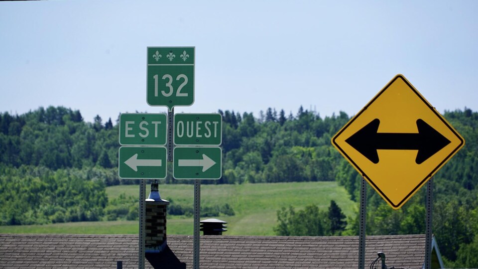 Des panneaux indiquent les directions Est et Ouest de la route 132.