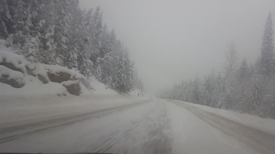Route enneigée lors d'une tempête de neige dans les Rocheuses.