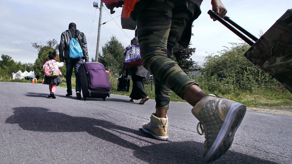 Une famille de demandeurs d'asile traverse la frontière canadienne.
