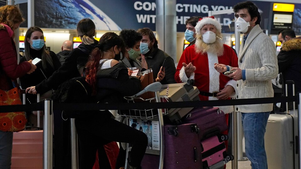 Plusieurs passagers font la file dans un terminal.