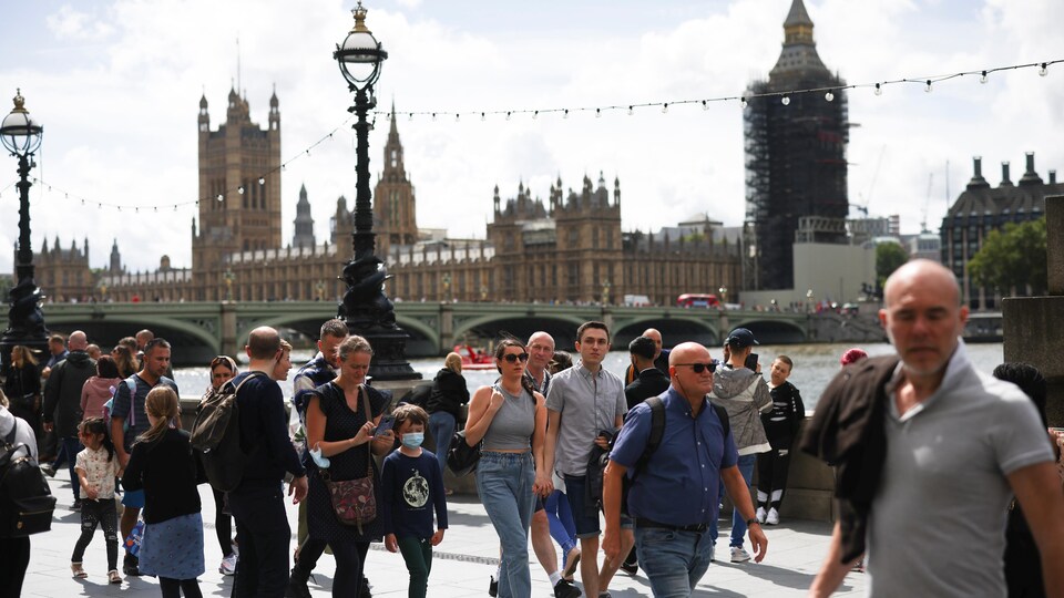 Une foule de gens sans masque marchent dans les rues de Londres.