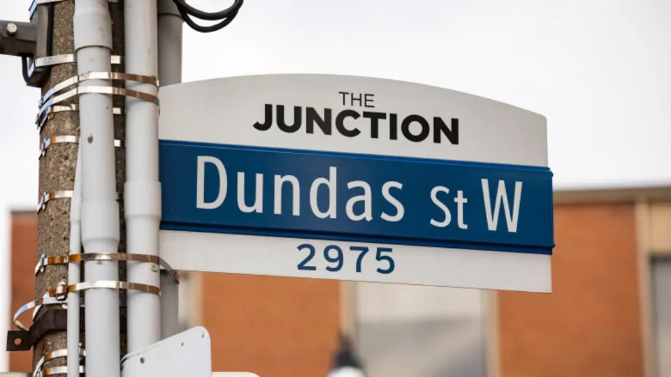 Un panneau de rue indiquant Dundas Street West.