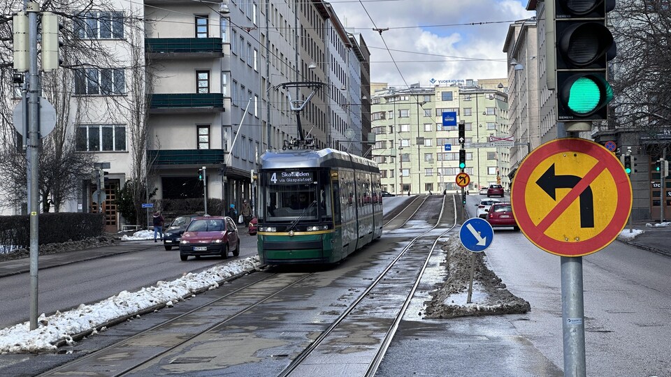 Une voie réservée pour le tramway au milieu avec des voitures chaque côté.