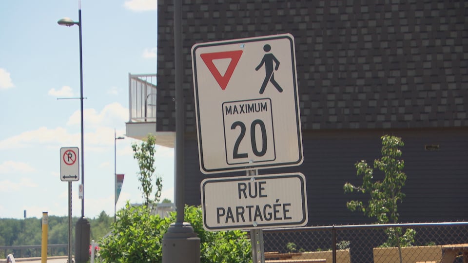 Un panneau qui indique que les piétons ont la priorité sur une rue.