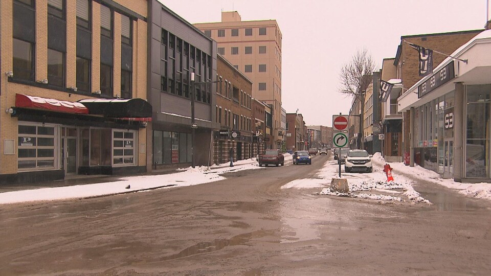 Quelques rares véhicules sont garés des deux côtés de la rue Racine.
