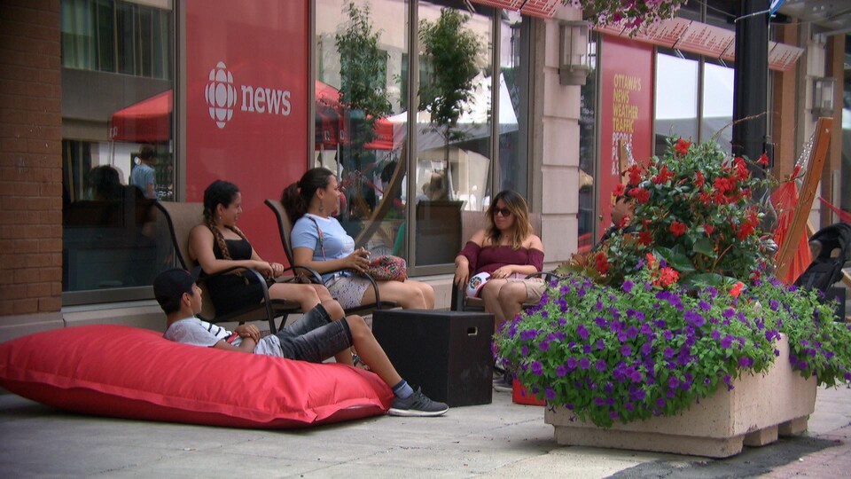 Des gens sont assis sur des chaises et des coussins sur la rue Sparks.
