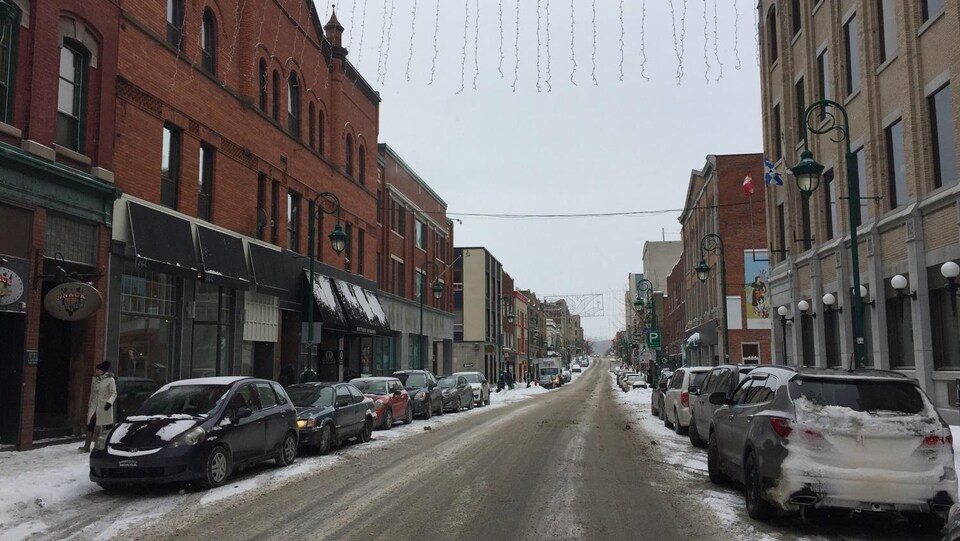 La rue Wellington Nord au centre-ville de Sherbrooke en hiver. Des voitures sont stationnés de chaque côté de la rue.