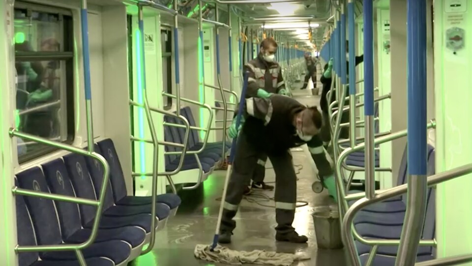 Une équipe de nettoyage s'affaire dans des voitures de métro.