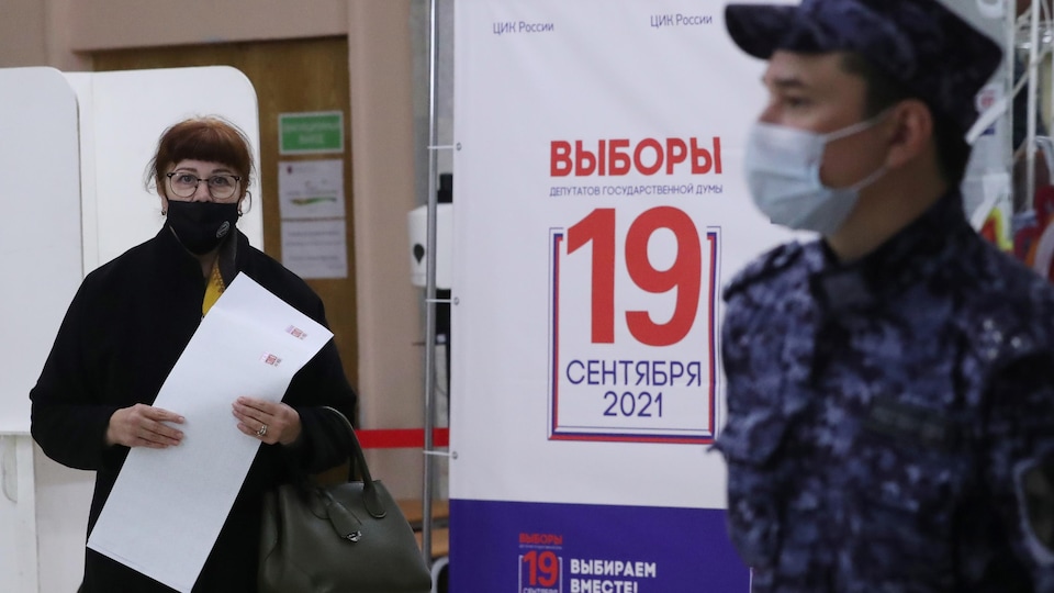 Moscow voter in an election office, voting by hand.