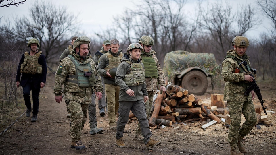 El presidente Zelensky, rodeado de soldados, usa ropa protectora.