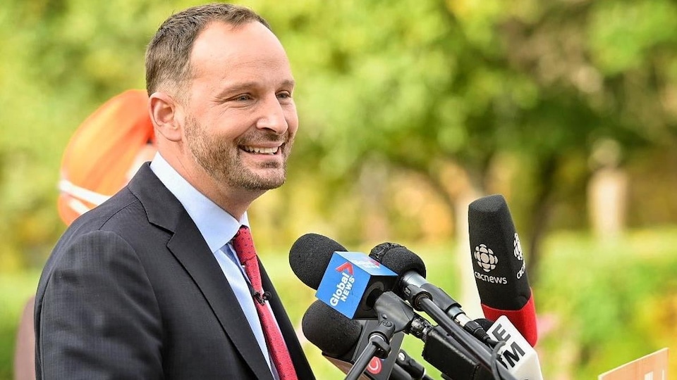 Ryan Meili, tout sourire devant les micros des journalistes.