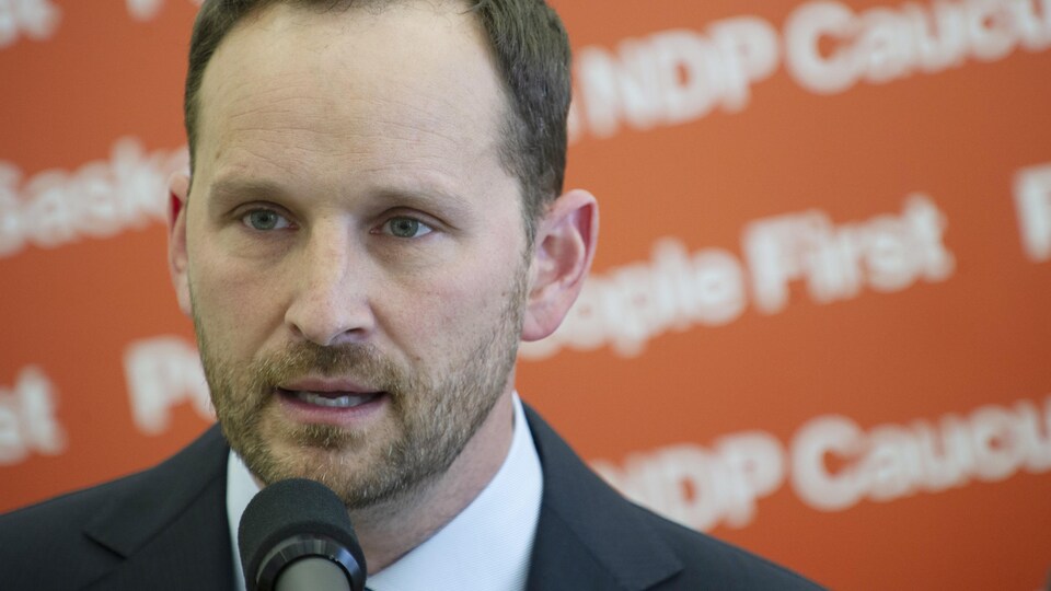 Debout devant un micro, Ryan Meili répond aux questions.