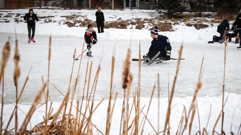 Ryan Straschnitzki jouant au hockey sur l'étang gelé derrière la maison familiale.