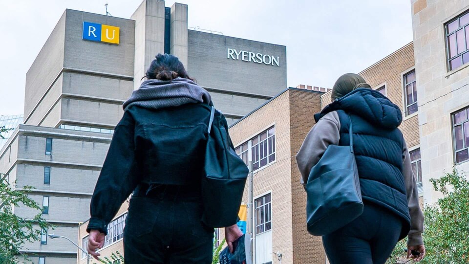 Deux personnes de dos devant un immeuble de l'Université Ryerson.