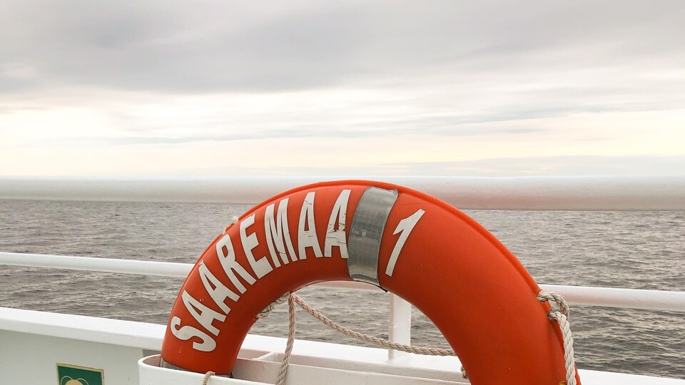 Une bouée de sauvetage rouge, attachée au bateau.
