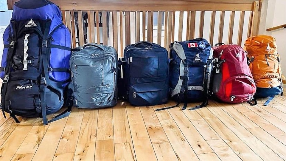 Des sacs à dos un à côté de l'autre près d'un escalier.