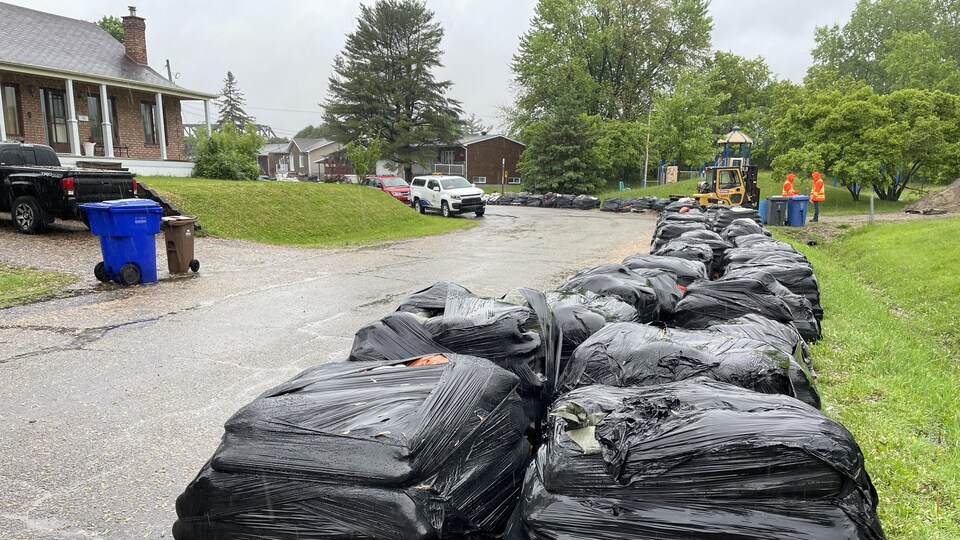 Des sacs de sable en guise de barricades pour protéger les maisons des inondations, dans un quartier résidentiel.
