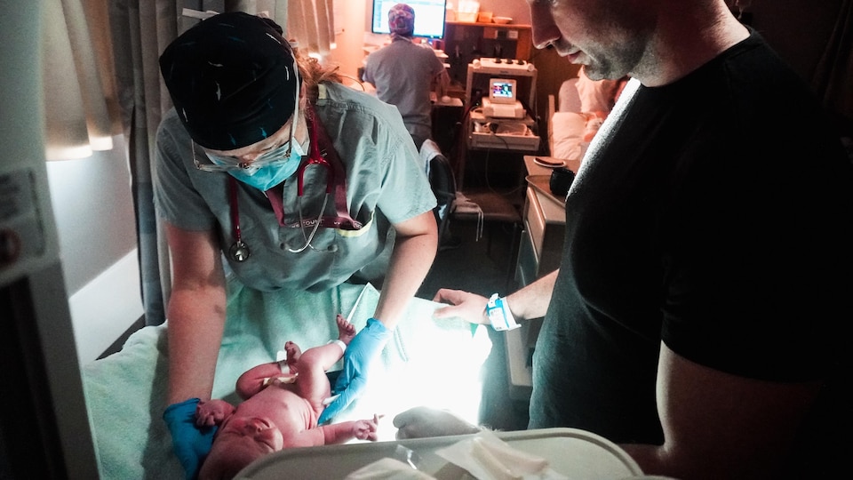 Colleen Fulton tient un bébé qui vient de faire naître.