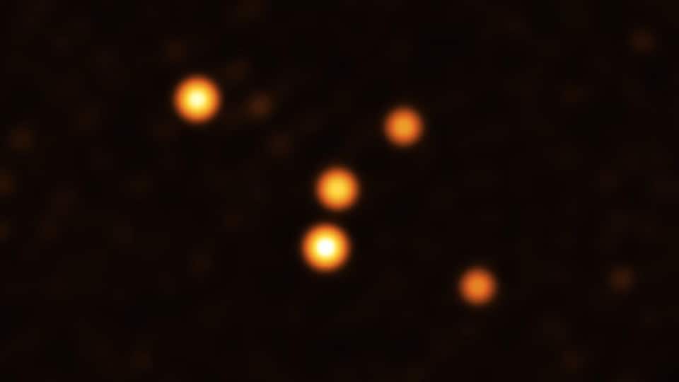 Cinque punti arancioni su sfondo nero.  L'immagine mostra le stelle in orbita vicino a Sgr A* (al centro), il buco nero supermassiccio nel cuore della Via Lattea.