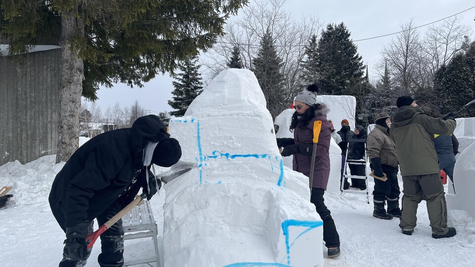 Des personnes font des sculptures de neige.