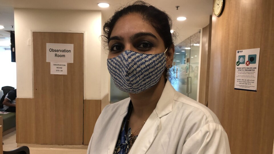 Sahar Qureshi porte un couvre-visage et un sarrau dans le corridor d'un hôpital.