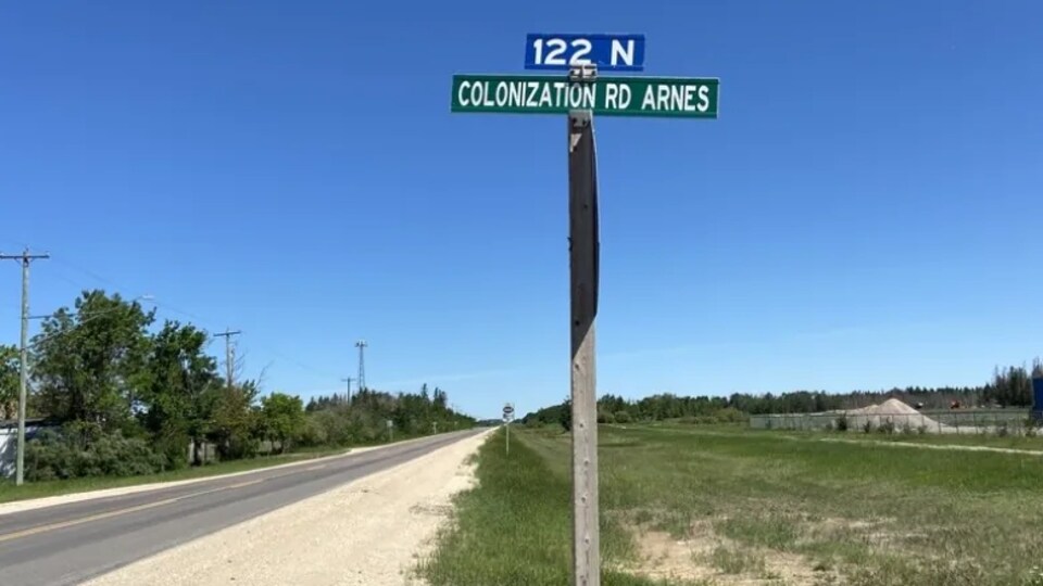 Un chemin, du gravier et du gazon. Un arrêt avec le nom du chemin qui porte le nom de « colonisation ».