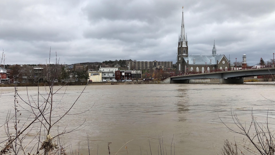 Le centre-ville de Sainte-Marie apparaît sous un ciel menaçant, alors que la rivière Chaudière atteint un niveau inquiétant près de l'église situé au coeur de la municipalité.