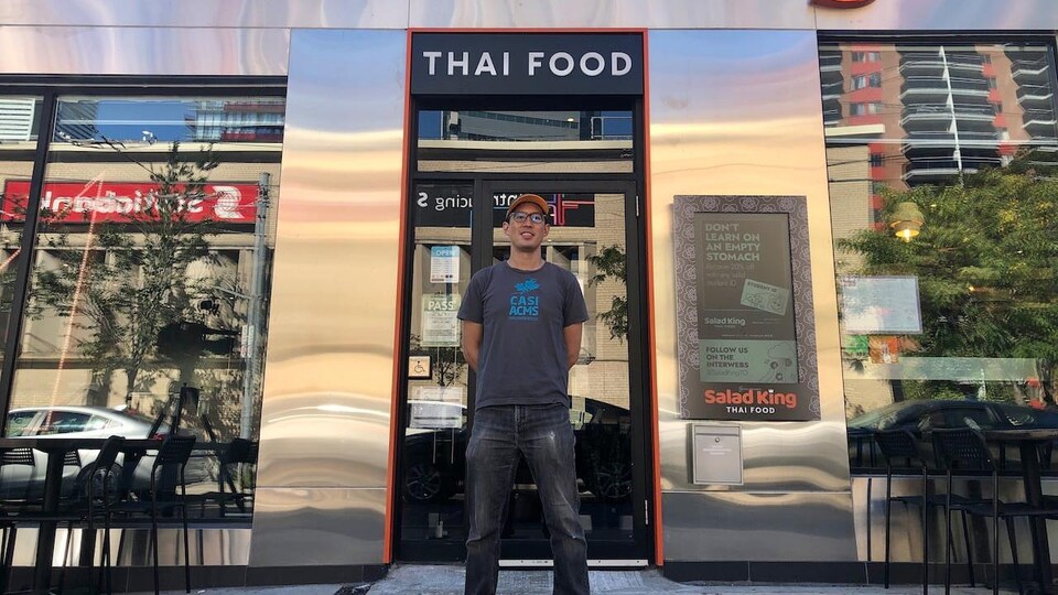 Un homme devant la façade d'un restaurant