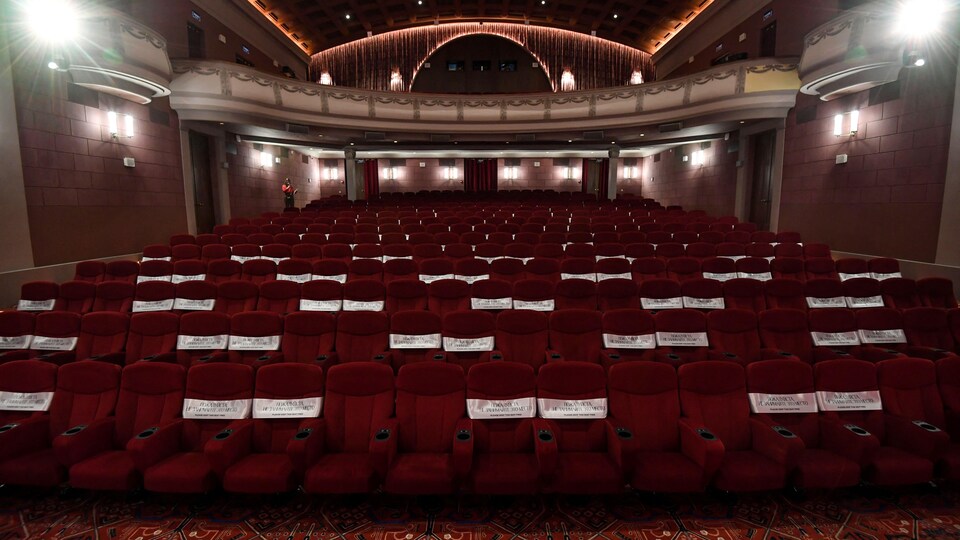 Vue de sièges feutrés rouges dans une salle de cinéma rétro. 