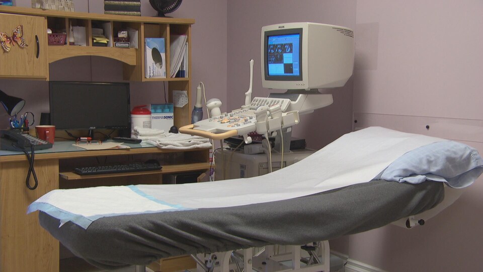Un lit d'examen médical dans une salle d'échographie.