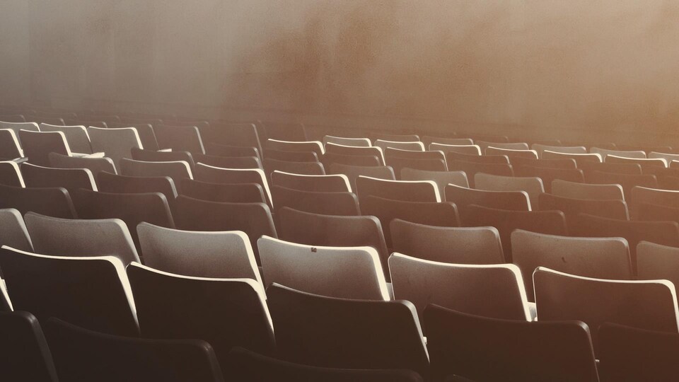 Des sièges vides dans une salle de spectacles.