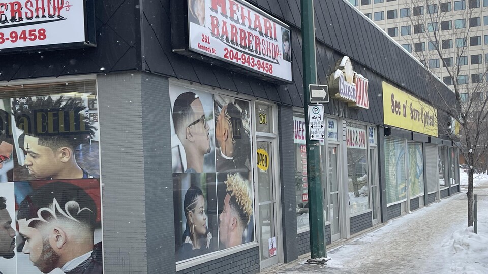 Un salon de coiffure à l'angle de deux rues du centre-ville de Winnipeg. 