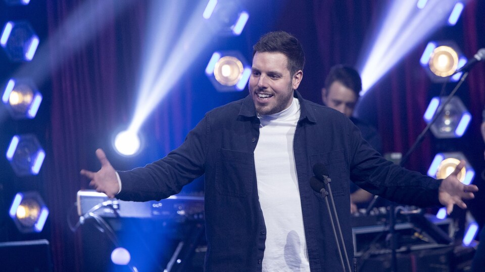 Sam Breton ouvre les bras sur scène.