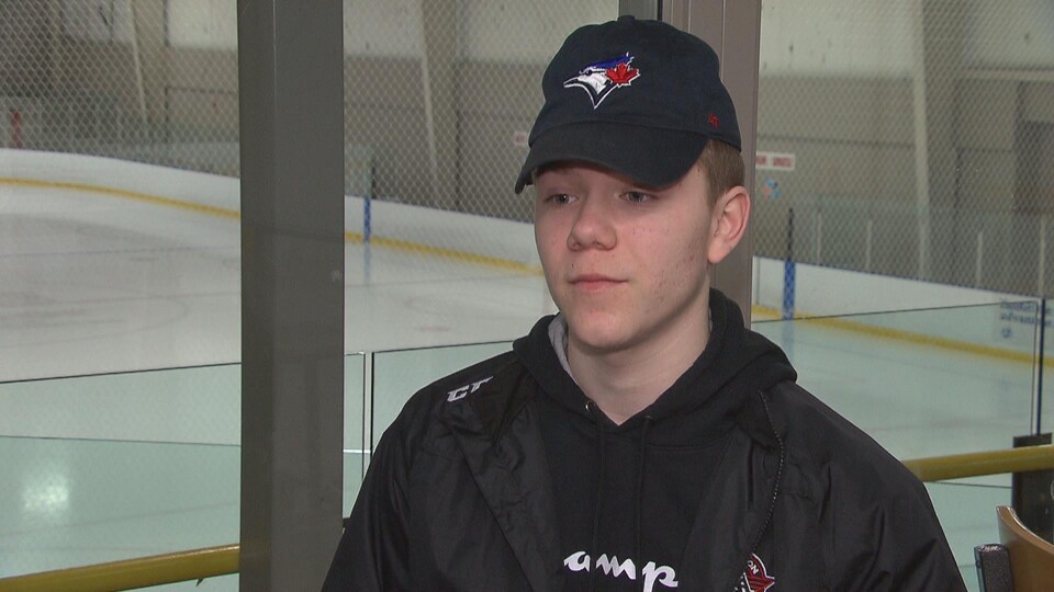 Un jeune homme devant une patinoire