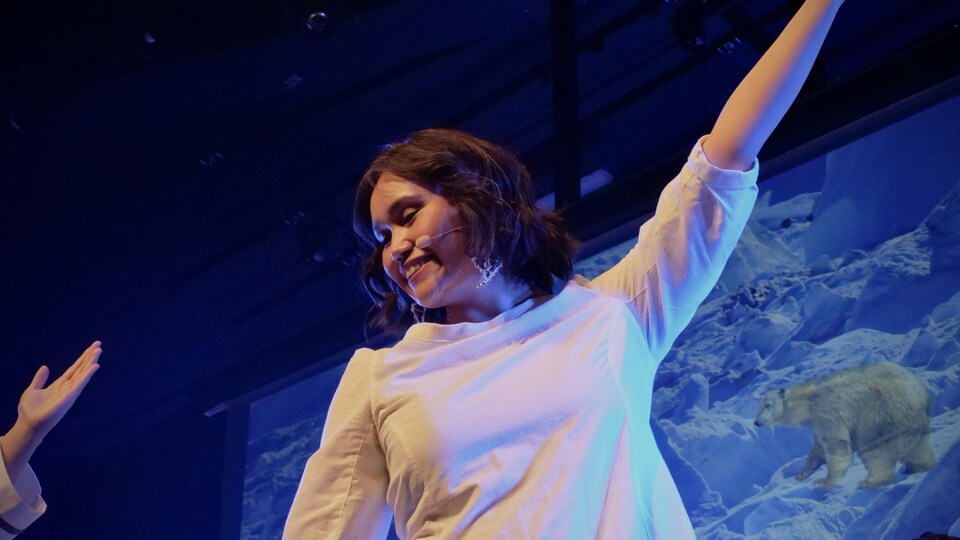 Une femme danse sur une scène à l'occasion d'un spectacle de danse du tambour.