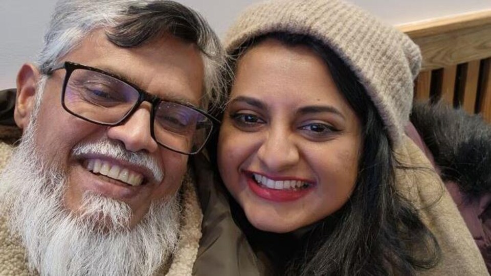 Un homme portant une barbe blanche avec sa fille, tout sourire.