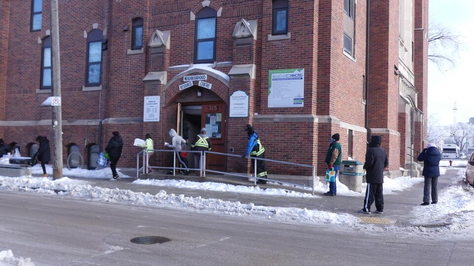 Des personnes font la queue à l'extérieur d'un centre de ressources.